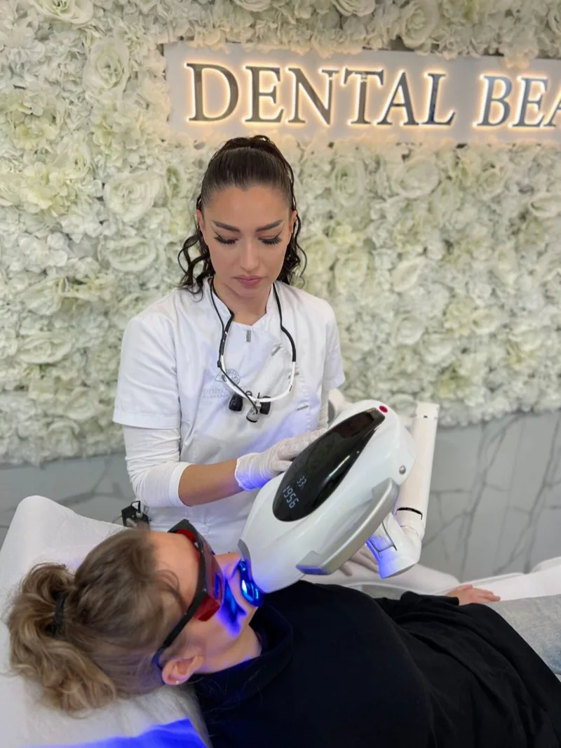 Elena Ulm richtet die LED-Lampe bei einer Kundin im Dental Beauty Studio aus